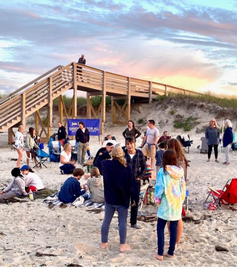 People gathered together on a beach talking